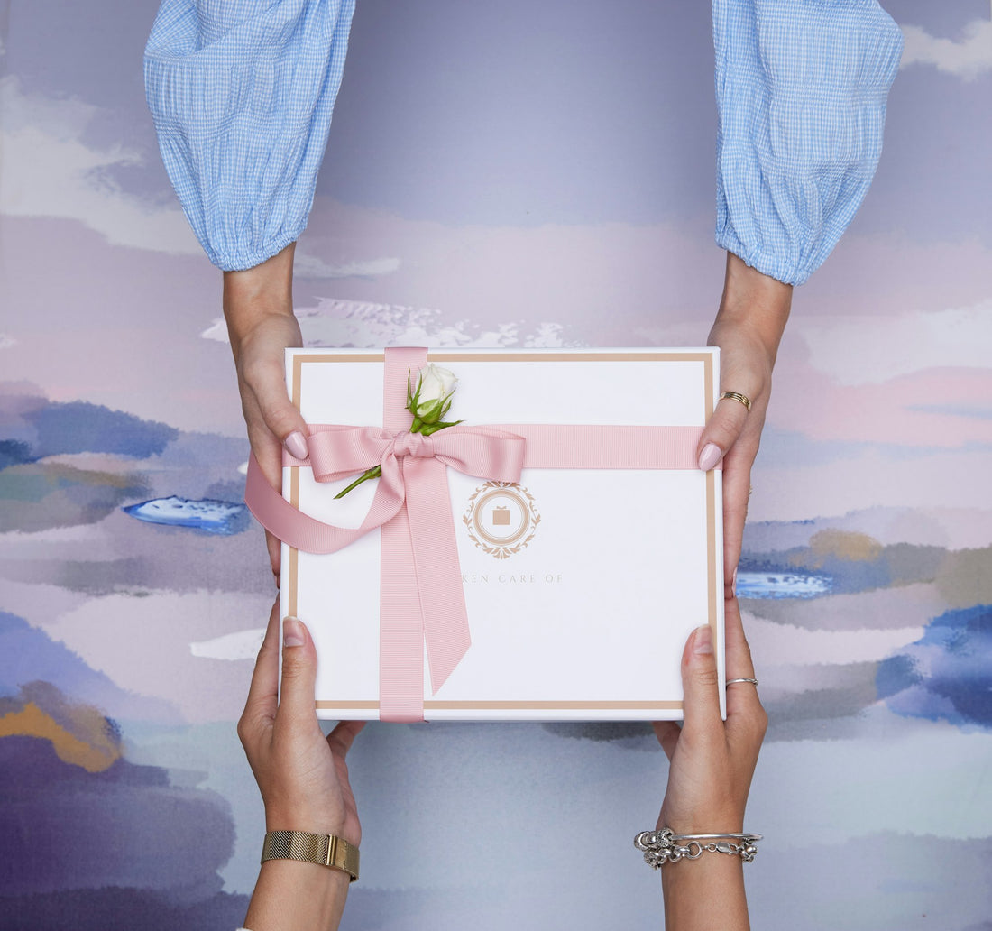 Two hands exchanging a wrapped gift box